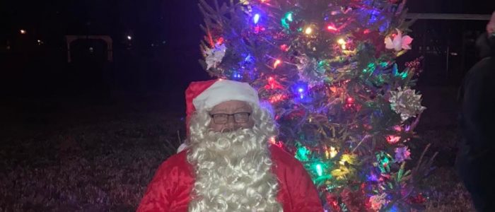 Picture of Santa in front of the Christmas Tree